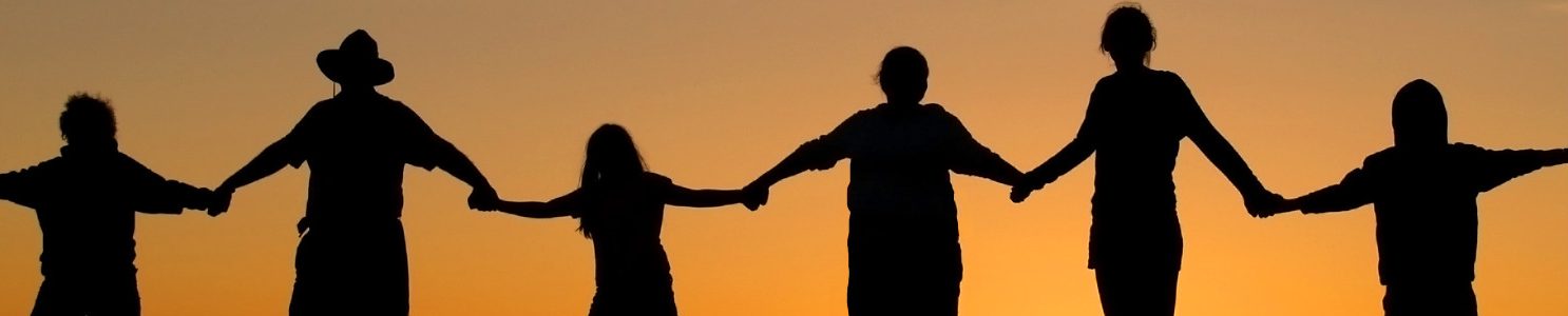 Silhouetten von Menschen, die sich vor einem Sonnenuntergang an den Händen halten